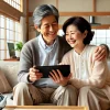 和風のリビングで寄り添いながらタブレットを見て微笑む、50代から60代の日本人夫婦。男性は肩を抱き寄せて、女性はリラックスした表情で画面を見つめている。背景には障子と伝統的な家具があり、落ち着いた和の雰囲気が漂う部屋。二人の温かな関係性が感じられる、家庭でのリラックスタイムを表現したシーン。