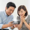 スマホゲームを楽しむ50代男女の笑顔。無料ダウンロードに安心している様子