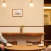50代の男女がカフェで穏やかに会話している様子。自然体で心地よい人間関係を象徴するシーン。