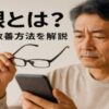 スマートフォンを見ながら老眼鏡を持ち上げ、画面を見づらそうにしている50代の日本人男性